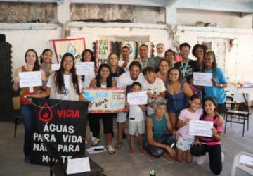 grupo de pessoas participantes da oficina com cartazes na mão sobre saneamento básico e acesso a água potável 