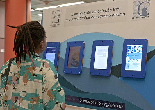 Mulher vendo telas de computador colocadas na parede como um quadro