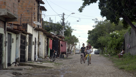 Pessoas andando de bicicleta em uma rua de terra batida