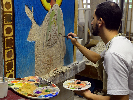 Foto de artista pintando um quadro