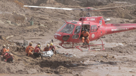 Helicóptero de resgate dos bombeiros retirando vítimas em meio ao lamaçal