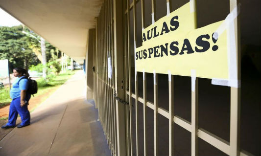 Escola fechada com uma faixa escrita: aulas suspensas
