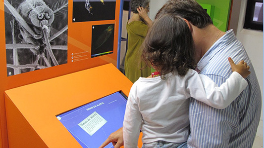 Foto de pai e filha visitando a exposição