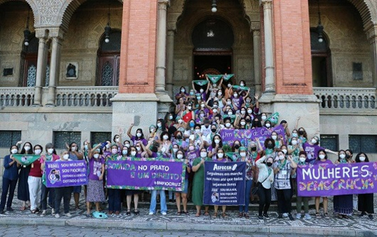 Mulheres reunidas em frente ao castelo Fiocruz