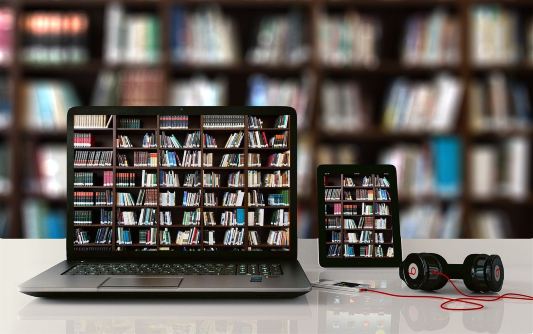 Computador na frente de uma estante de livros