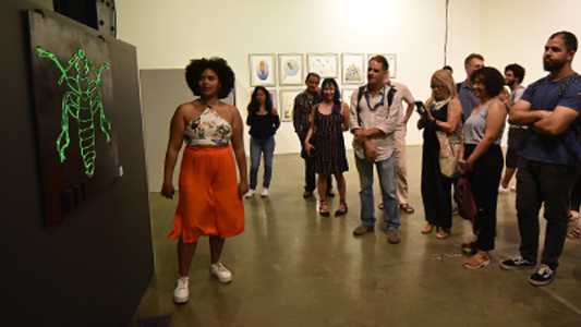 Pessoas observando a exposição
