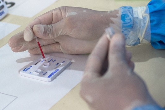Mãos enluvadas realizam procedimento de teste em laboratório