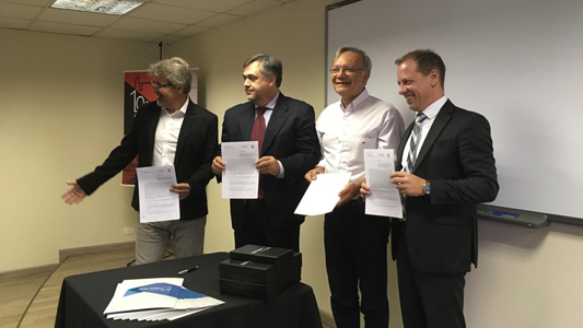 Representantes das instituições mostrando o memorando assinado