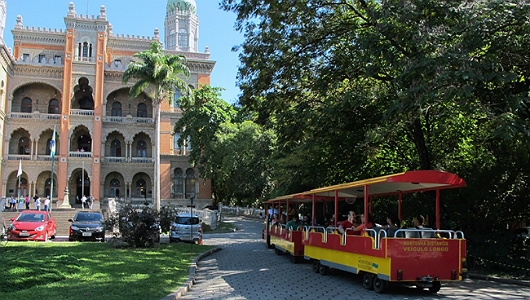 Foto mostra o trenzinho do museu, na frente do Castelo da Fiocruz