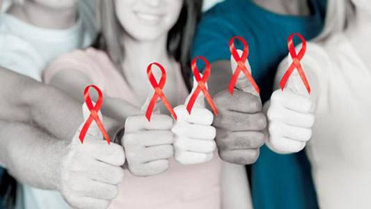 Foto de quatro pessoas com o laço vermelho no dedo polegar