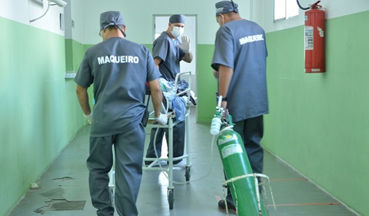 Profissionais carregando tubos de oxigênio
