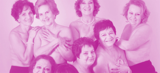 Sete mulheres reunidas com as mãos na frente dos seios