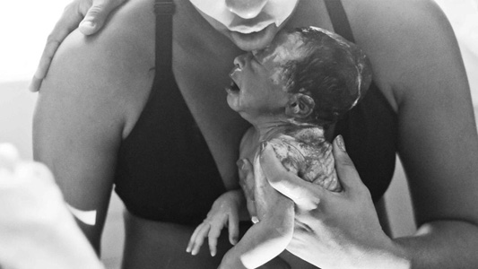 Mãe com bebê recém-nascido no colo