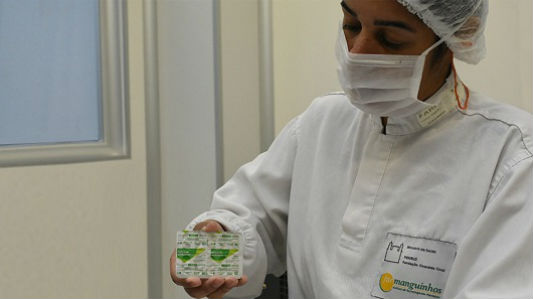 Farmacêutica segurando uma caixa do medicamento