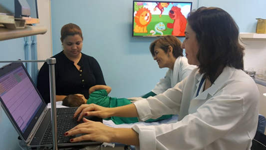 Médicas tratando bebê na frente da mãe