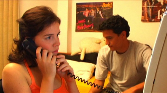 Mulher falando no telefone e homem preocupado olhando