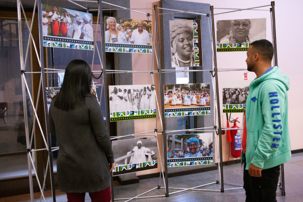 Duas pessoas vendo fotos de José Marmo na exposição