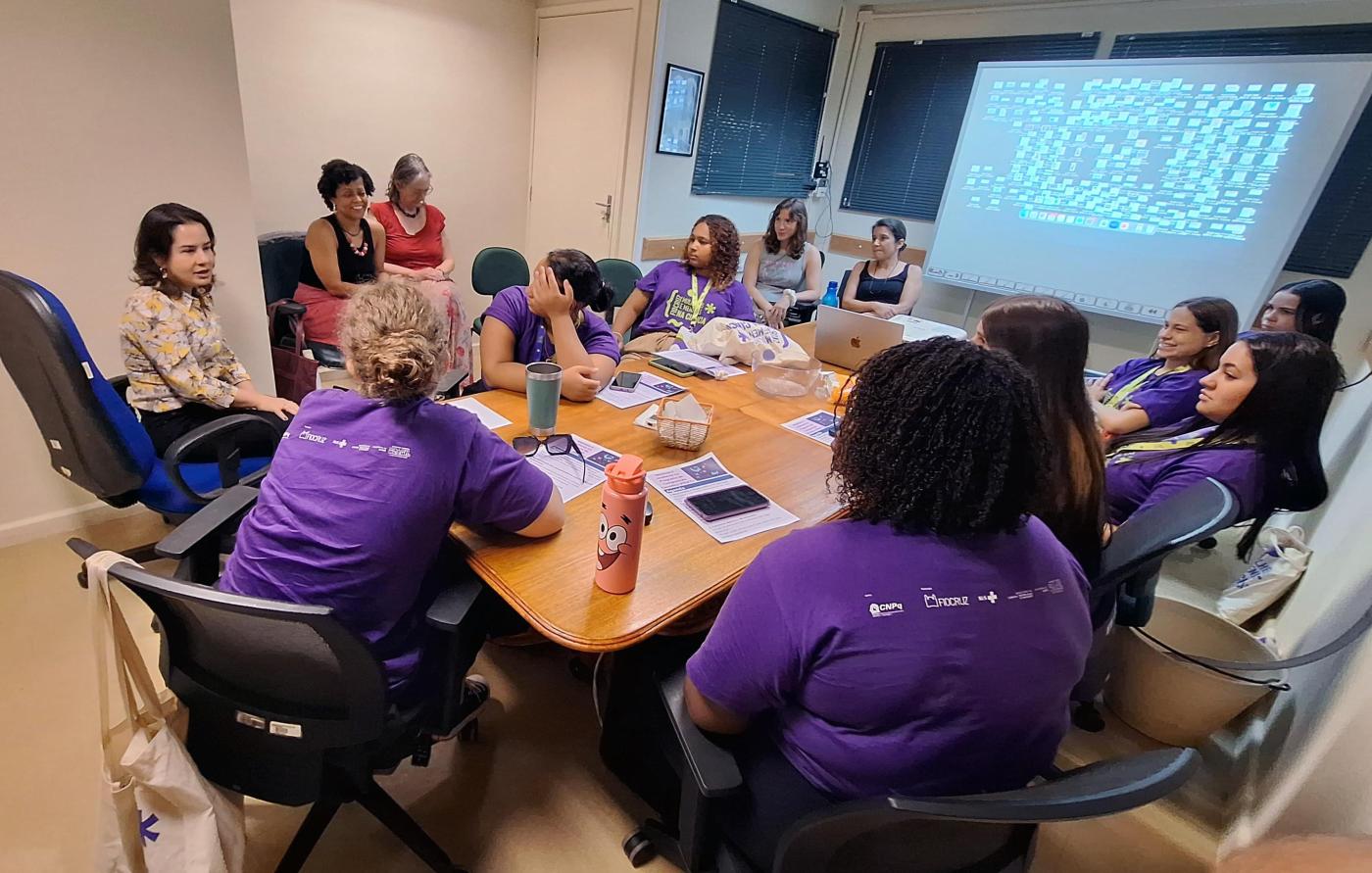 Pesquisadoras do PROCC e estudantes do ensino médio em encontro numa sala no PROCC