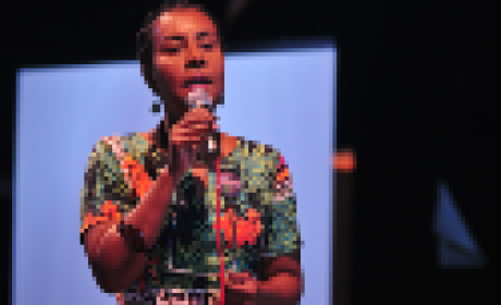 Hilda Gomes em pé segurando um microfone