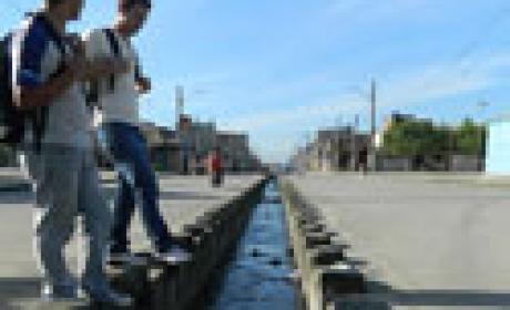 Jovens participantes do projeto CEnaRios vão aos bairros em que vivem, na Zona Norte carioca, para mapear seus problemas socioambientais (Foto: equipe do CEnaRios) Dois jovens observam vala com água suja