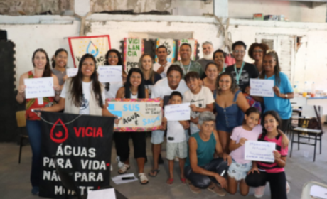 grupo de pessoas participantes da oficina com cartazes na mão sobre saneamento básico e acesso a água potável 