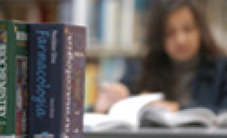 Moça lê numa biblioteca