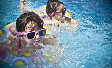 Foto: Pixabay Crianças com óculos escuros mergulhando na piscina