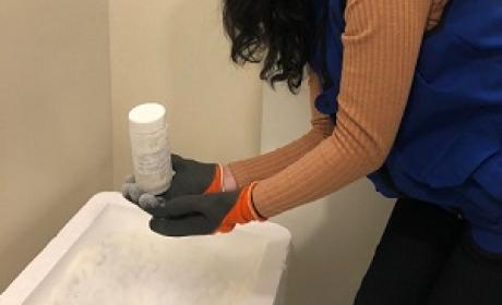 Funcionária do IFF segurando um frasco de leite humano para doação