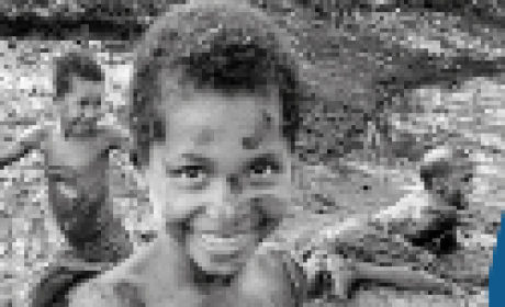 Foto de três meninos brincando na lama na beira de um rio