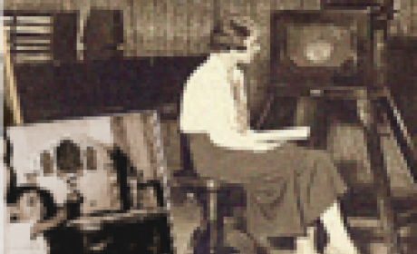 Foto antiga, em sépia, de uma mulher de perfil sentada em uma sala