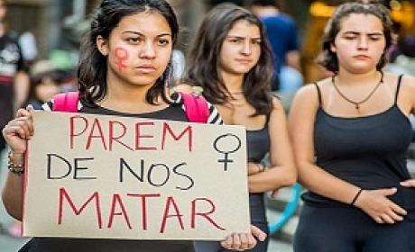 Mulher segura um cartaz com o texto: "Parem de nos matar" 