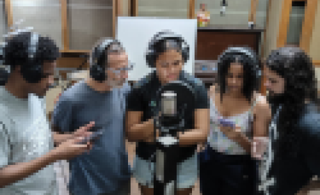 Três pessoas cantando em um estúdio