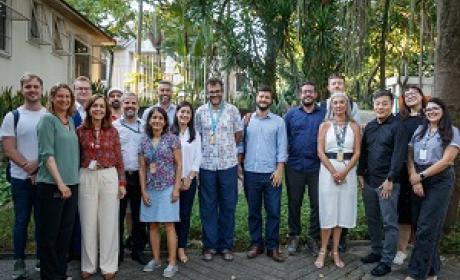 Cerca de 20 participantes da reunião de pé posando para a foto
