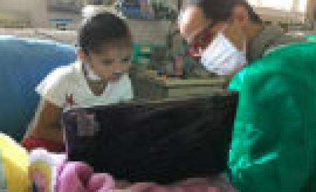 Voluntários mais jovens se organizaram para conseguir cestas básicas e leite especial para as crianças com necessidades especiais (Foto: IFF) Voluntário com uma criança