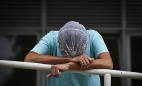 Profissional de saúde de cabeça baixa e cansado