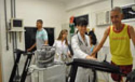 A educadora física Vivian Mattos (primeira à esquerda) e a médica Fernanda Sardinha monitoram os pacientes durante os exercícios (Foto: Carolina Landi) Fotografia de profissionais de saúde orientando pacientes no uso da esteira ergométrica