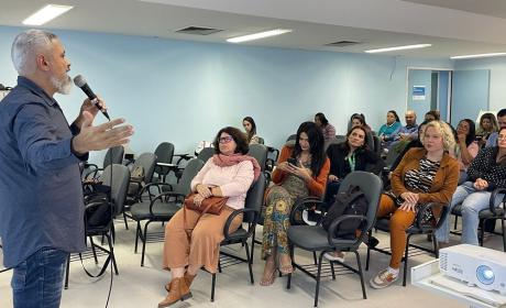 imagem do juiz André Brito conversando com pessoas durante palestra na sala de treinamentos da CST