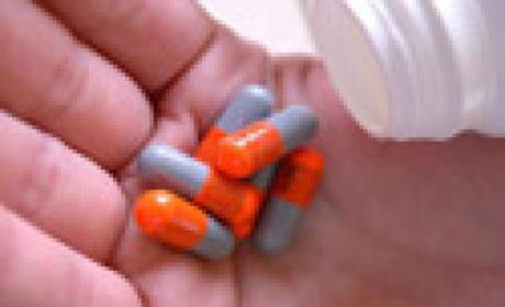 Detalhe de mão segurando vários comprimidos de um medicamento qualquer