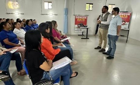 Pessoas assistem à palestra sobre dengue em sala de aula