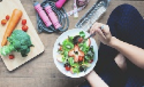 Imagem: IFF Mulher sentada no chão comendo um prato de salada
