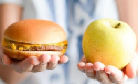 O dia 3 de maio é marcado pela OMS como o Dia da Conscientização Contra a Obesidade Mórbida Infantil (Imagem: IFF) Uma maça em uma mão e um hamburger em outra