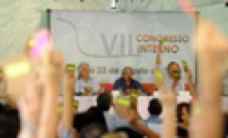Foto: Peter Ilicciev/ Agência Fiocruz de Notícias Plenária: mãos levantadas exibindo papéis coloridos com votos