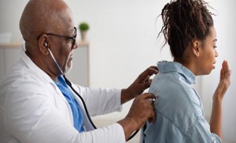 Médico examina pulmões de uma paciente