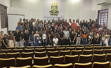 Grupo de pessoas posa para foto em auditório a Universidade Regional do Cariri.