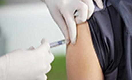 Foto de mãos profissional de saúde usando luvas e aplicando vacina no braço de uma pessoa