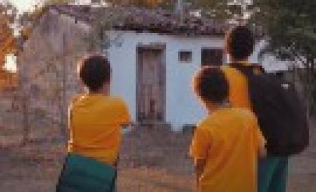 Imagem: divulgação Três crianças em frente a uma casa
