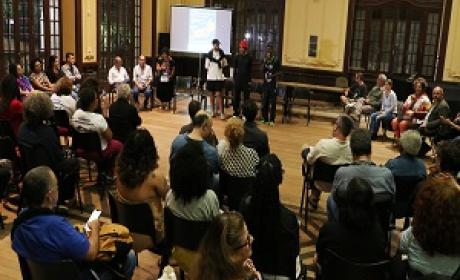 Foto de participantes em semi-círculo, com destaque para pessoas que falam no momento Foto de participantes em semi-círculo, com destaque para pessoas que falam no momento