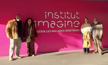 comitiva posa na frente de uma parede rosa com o título "Institut Imagine"