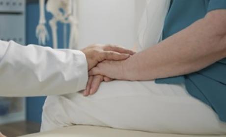 Médico e paciente de mãos dadas